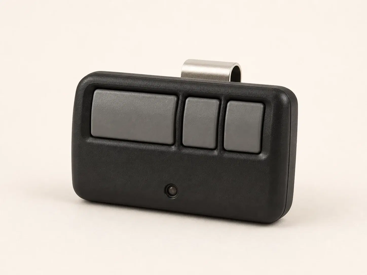 Illustrative rendering of a compact black visor remote with one wide and two narrow buttons