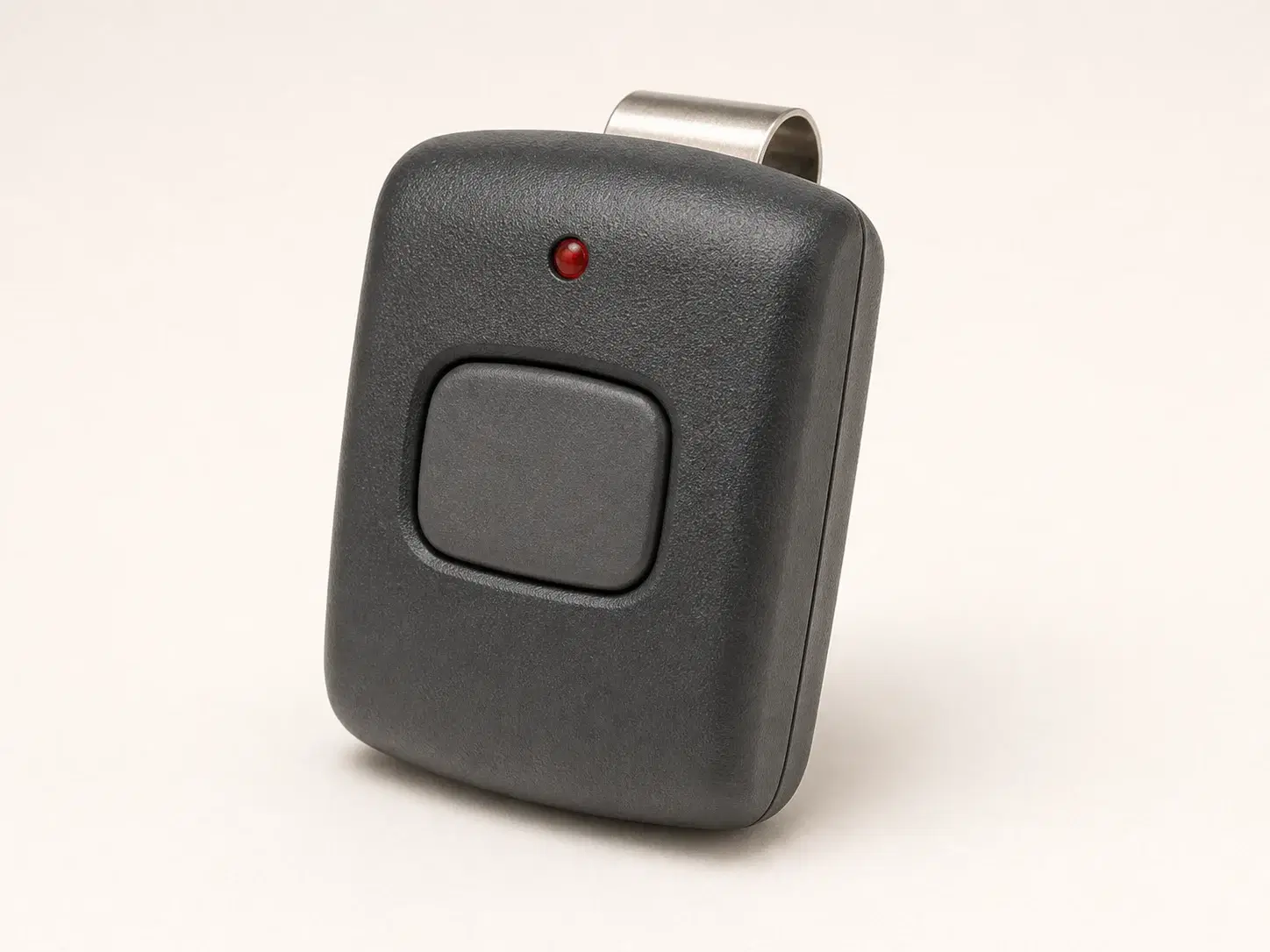 Illustrative rendering of a dark charcoal visor remote with one large tactile button